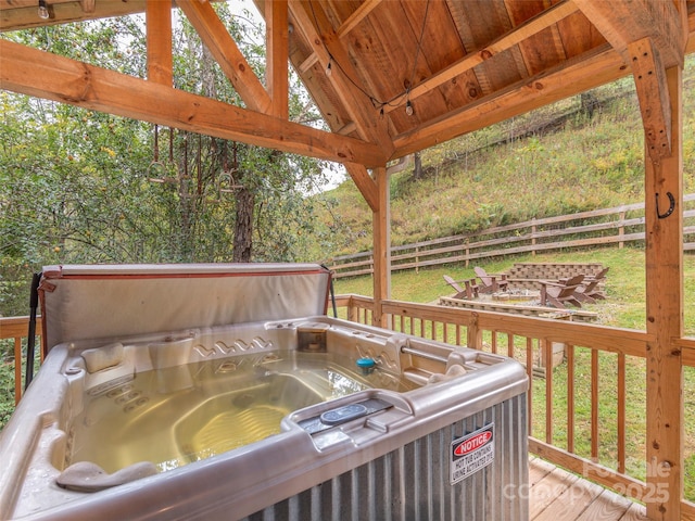 deck with fence, an outdoor fire pit, a gazebo, and a hot tub