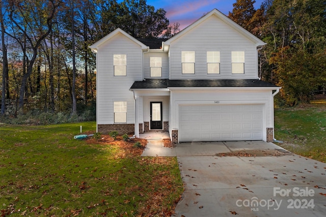 view of front property with a lawn and a garage