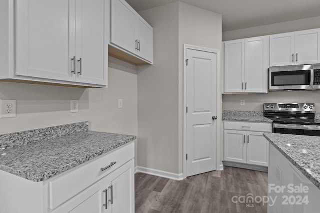 1403 Gentry Pl, Salisbury, NC 28146 - kitchen with stainless steel appliances, dark wood-style flooring, white cabinetry, and baseboards