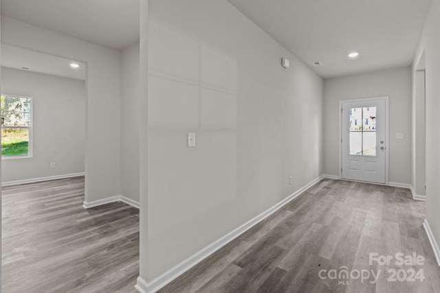 corridor with a healthy amount of sunlight and hardwood / wood-style floors