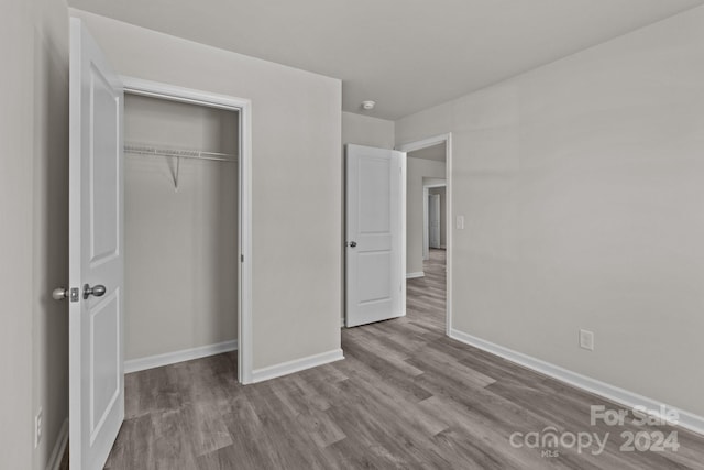 unfurnished bedroom with light hardwood / wood-style floors and a closet