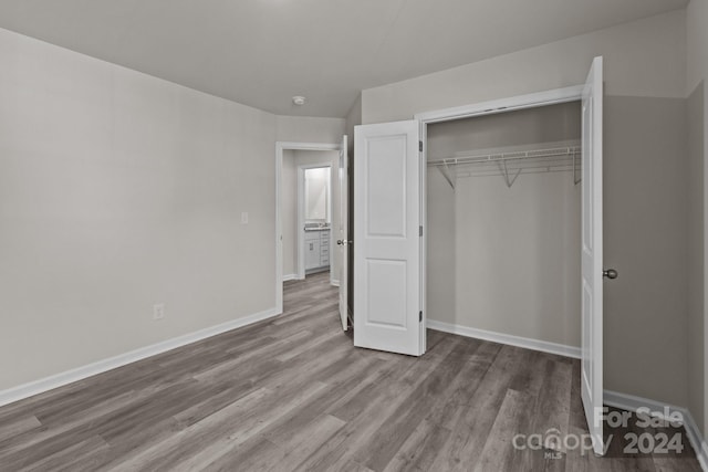 unfurnished bedroom featuring a closet and hardwood / wood-style flooring