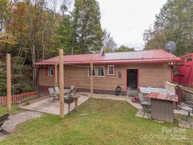 rear view of property with a lawn and a patio