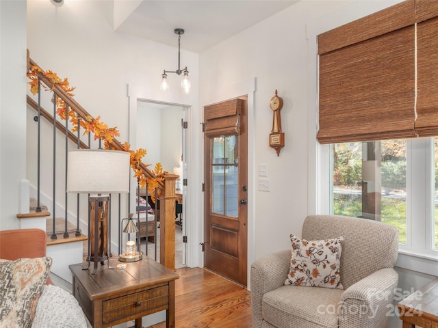 living room featuring wood-type flooring and an inviting chandelier