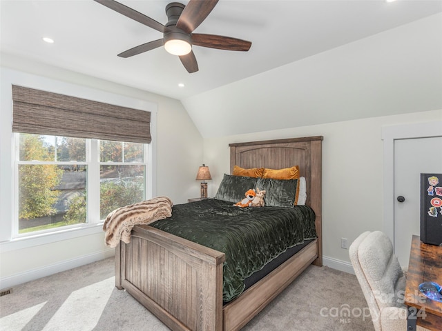 bedroom with ceiling fan, light colored carpet, and lofted ceiling