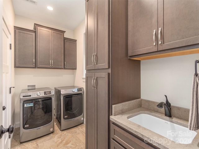 washroom featuring cabinets, washer and dryer, and sink