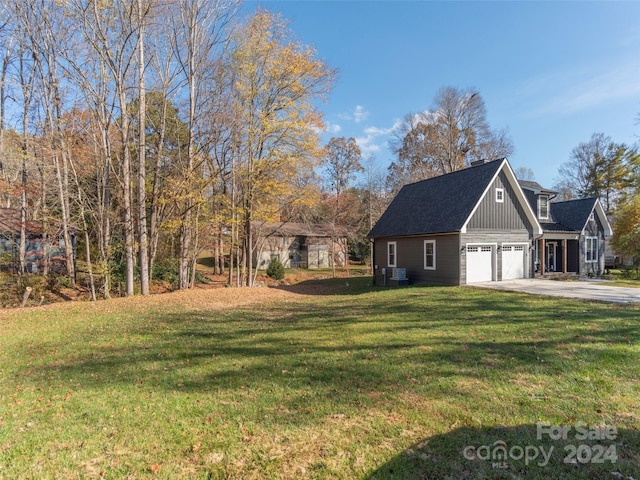 exterior space with central AC, a yard, and a garage