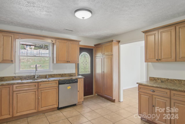 kitchen featuring light stone countertops, dishwasher, sink, a textured ceiling, and light tile patterned flooring