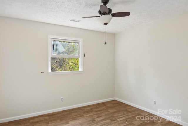 spare room with ceiling fan, hardwood / wood-style floors, and a textured ceiling