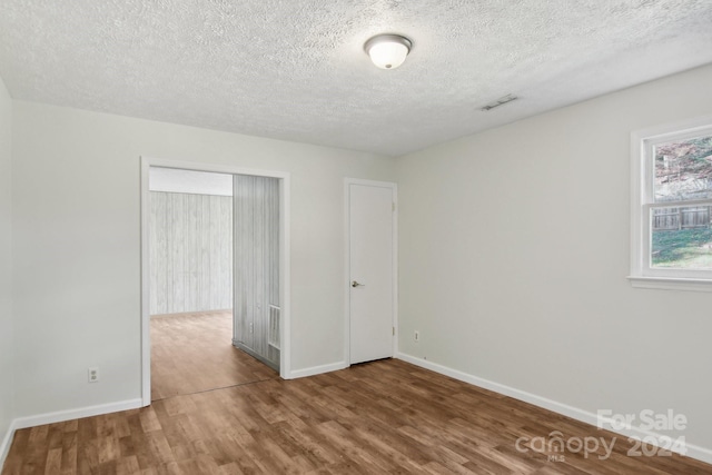 spare room with hardwood / wood-style floors and a textured ceiling