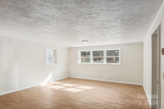 empty room featuring a textured ceiling and light wood-type flooring