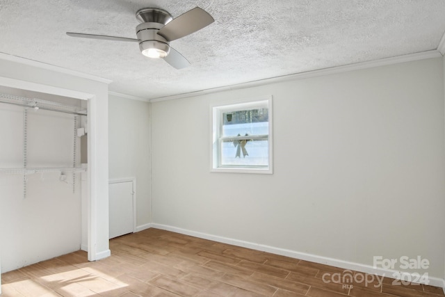 unfurnished bedroom with ornamental molding, a textured ceiling, ceiling fan, light hardwood / wood-style floors, and a closet