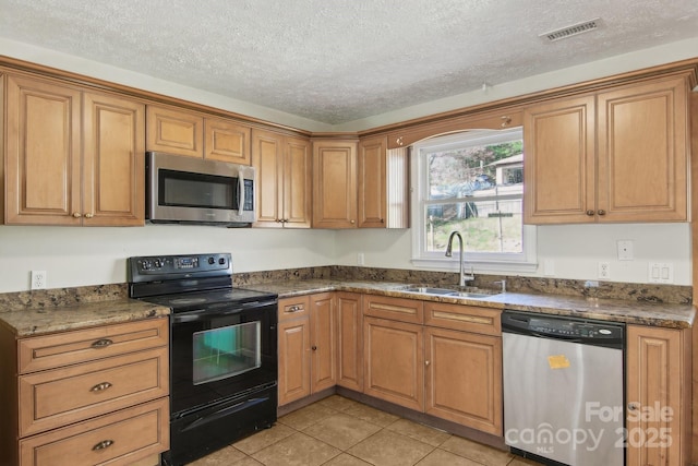 821 Anne Ave W, Hendersonville, NC 28739 - kitchen featuring stainless steel appliances, a sink, a textured ceiling, light tile patterned floors, and brown cabinetry