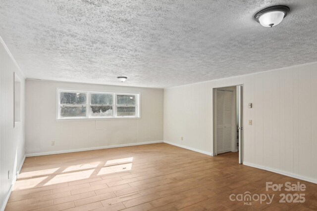 821 Anne Ave W, Hendersonville, NC 28739 - empty room with wood finished floors, baseboards, and a textured ceiling