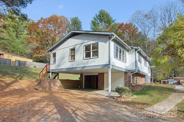821 Anne Ave W, Hendersonville, NC 28739 - view of side of home with a carport, stairs, driveway, fence, and brick siding