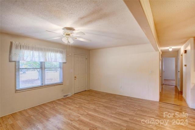 unfurnished room featuring light hardwood / wood-style floors, a textured ceiling, and ceiling fan