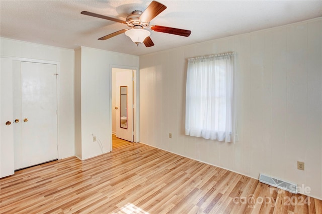 unfurnished bedroom featuring ceiling fan, a closet, and light hardwood / wood-style flooring