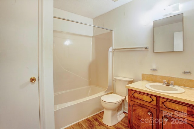 full bathroom with hardwood / wood-style floors, vanity, toilet, and  shower combination