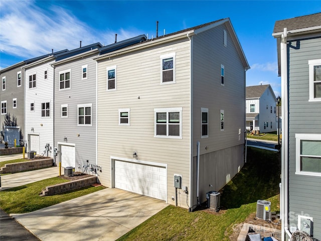 rear view of property featuring a garage and central AC