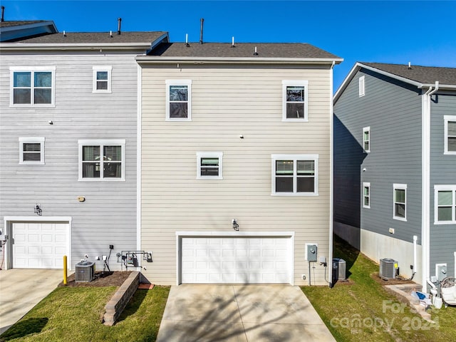 back of property with central air condition unit and a garage