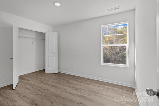 unfurnished bedroom featuring a closet and light hardwood / wood-style flooring