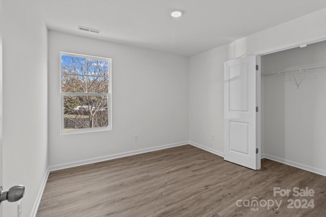 unfurnished bedroom with a closet and light wood-type flooring