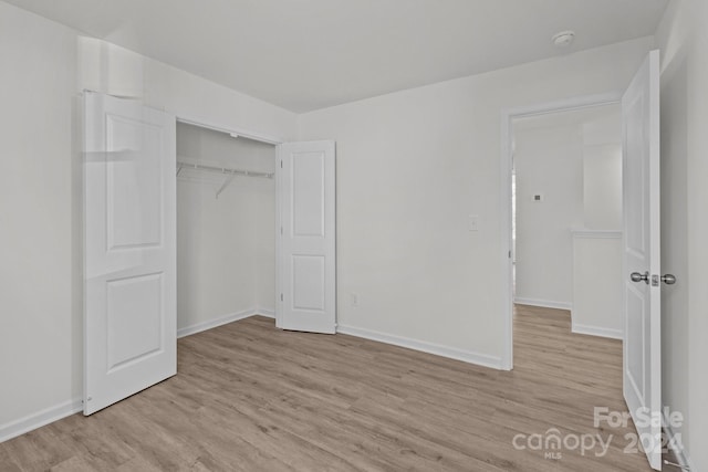 unfurnished bedroom with light hardwood / wood-style flooring and a closet