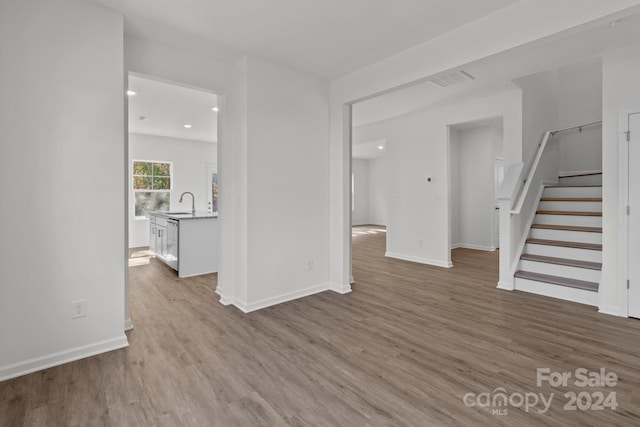 unfurnished living room featuring sink and light wood-type flooring