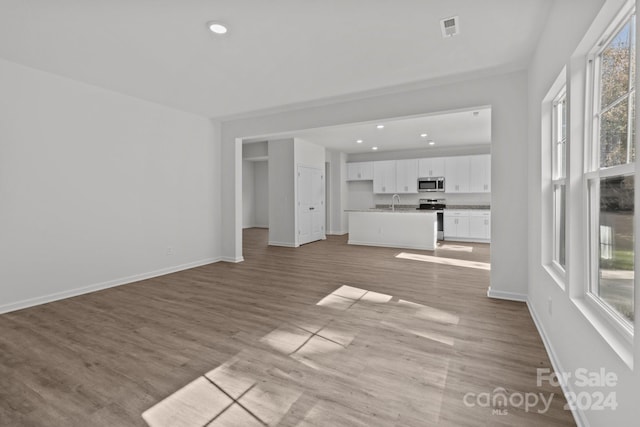 unfurnished living room with sink and light wood-type flooring