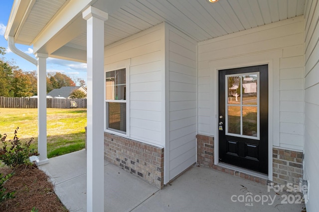 view of exterior entry with a lawn