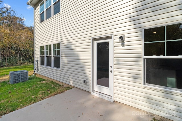 view of exterior entry featuring a patio and a yard