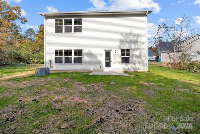 back of house featuring central air condition unit, a patio area, and a lawn