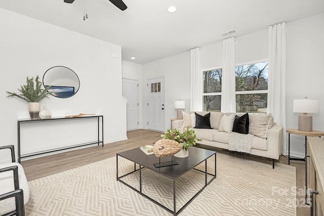 living room with light hardwood / wood-style floors and ceiling fan