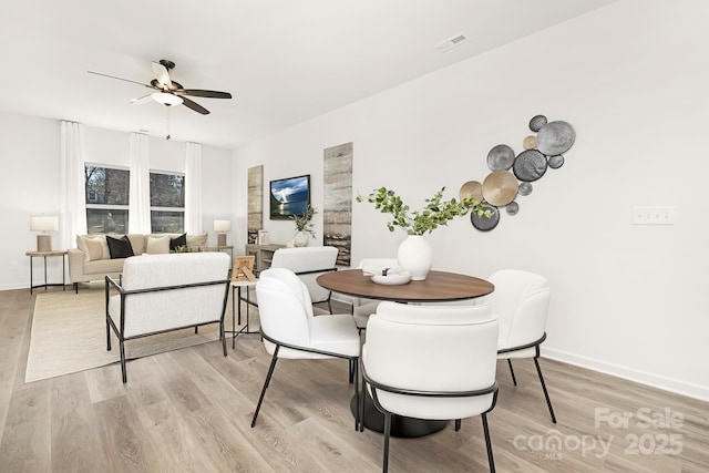 dining area featuring ceiling fan and light wood-type flooring