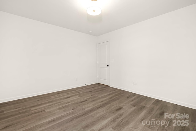 unfurnished room with dark wood-type flooring