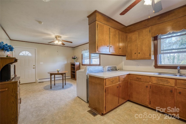 kitchen with washing machine and dryer, sink, ceiling fan, and a baseboard radiator