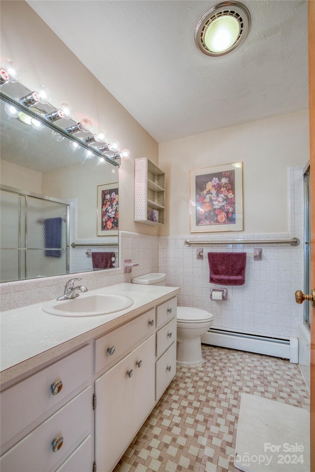 bathroom with vanity, an enclosed shower, a baseboard radiator, toilet, and tile walls