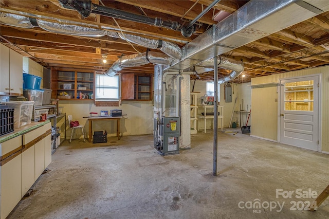 basement with electric panel and heating unit