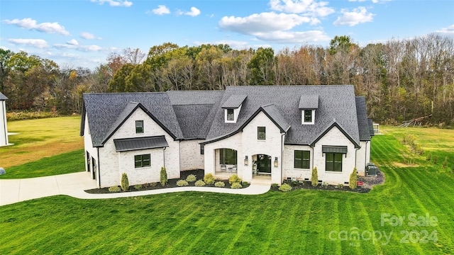 view of front of house featuring a front lawn and central AC unit