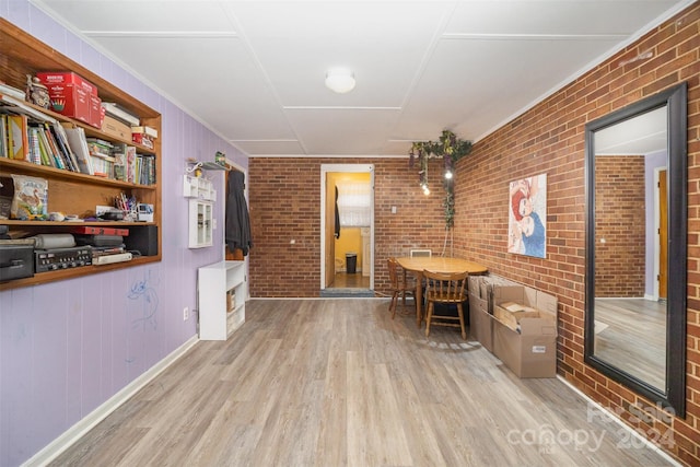 interior space with light hardwood / wood-style floors and brick wall