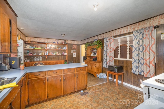 kitchen featuring electric range, light tile patterned floors, and a textured ceiling