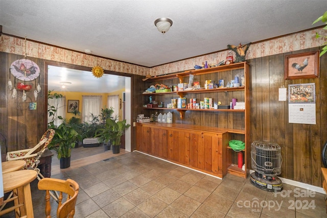 bar with tile patterned flooring, wood walls, and a textured ceiling