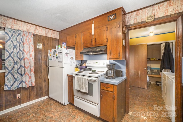 kitchen with a textured ceiling, wooden walls, and white appliances