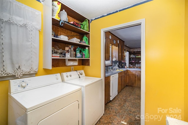 clothes washing area featuring washer and clothes dryer and a textured ceiling