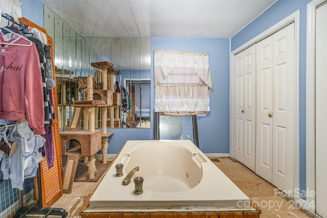 bathroom with a textured ceiling and a bathtub