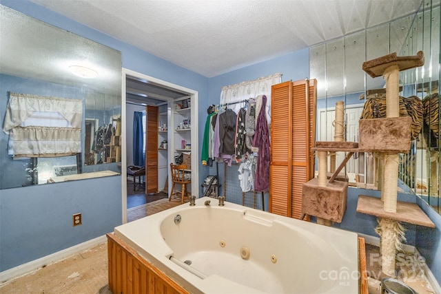 bathroom with a tub and a textured ceiling