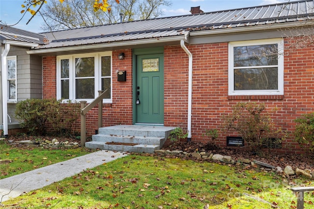 property entrance featuring a lawn