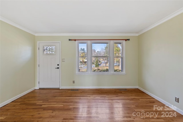 foyer entrance with crown molding and hardwood / wood-style floors