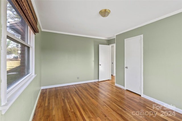 spare room featuring hardwood / wood-style floors and ornamental molding