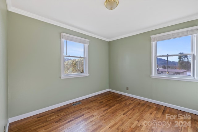 unfurnished room with hardwood / wood-style floors and ornamental molding